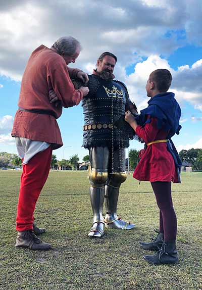 squires armouring up a knight